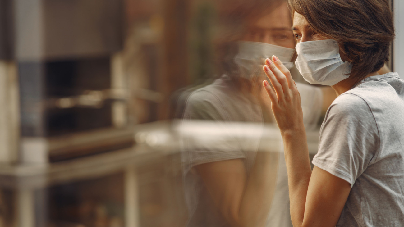 Woman in mask. Coronavirus theme. Lady by the window.