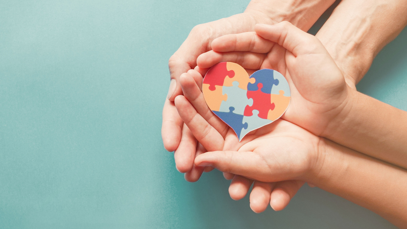 Adult and chiild hands holding jigsaw puzzle heart shape, Autism awareness, Autism spectrum family support concept, World Autism Awareness Day