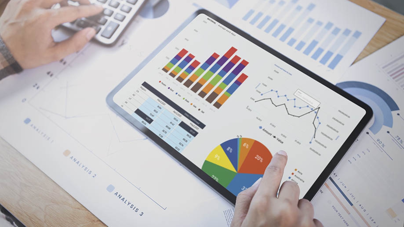 Businesswoman using a tablet to analysis graph company finance strategy statistics success concept and planning for future in office room.