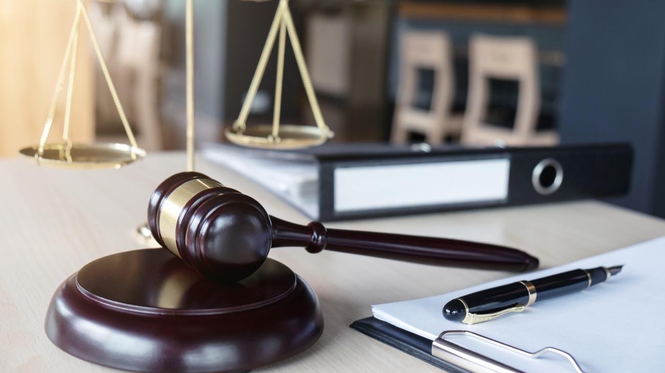 Close up of gavel and scales of justice and Report the case with paper on wooden table in office, Law and justice concept.